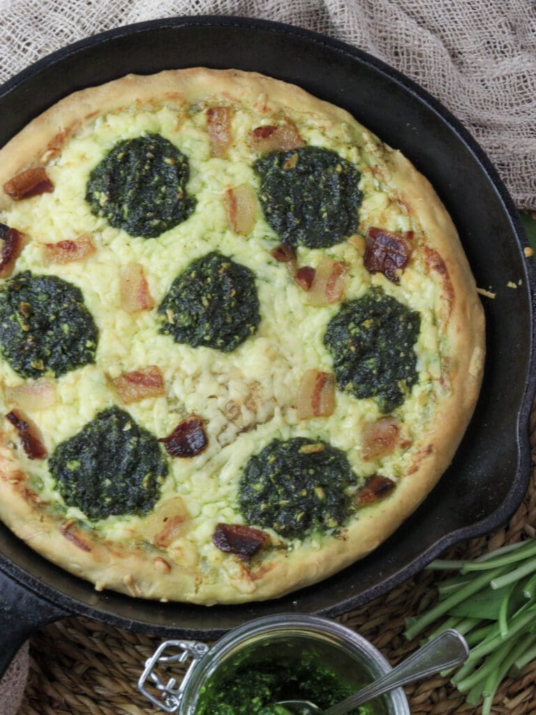 image of freshly baked wild garlic pizza coming out of the oven